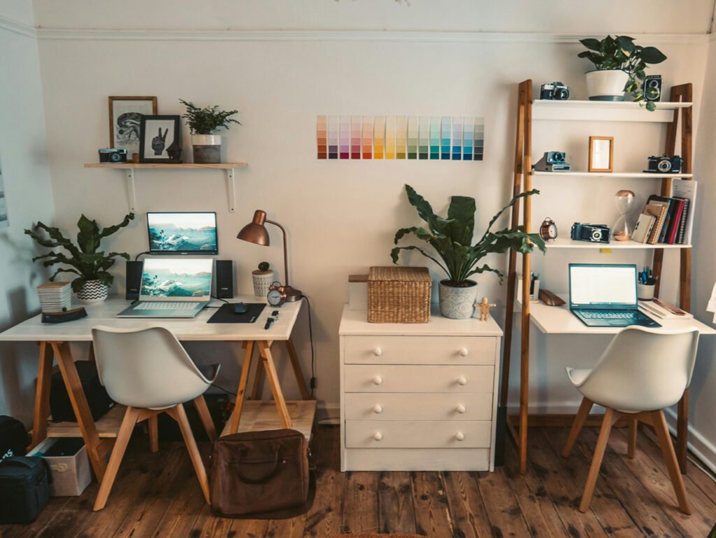 Espacio de oficina en casa con dos puestos de escritorio y objetos decorativos.